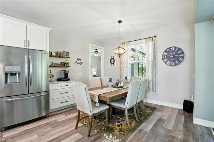 Dining space with light wood-style flooring, a chandelier, and a ceiling fan