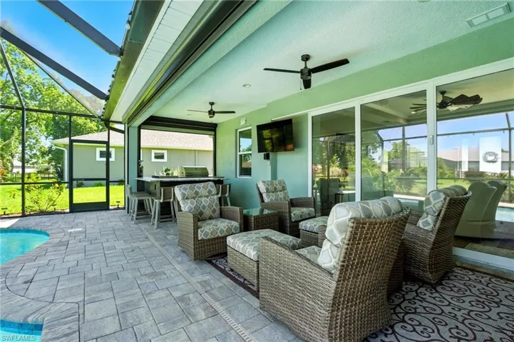 View of patio / terrace featuring a sunroom, glass enclosure, an outdoor pool, and outdoor lounge area