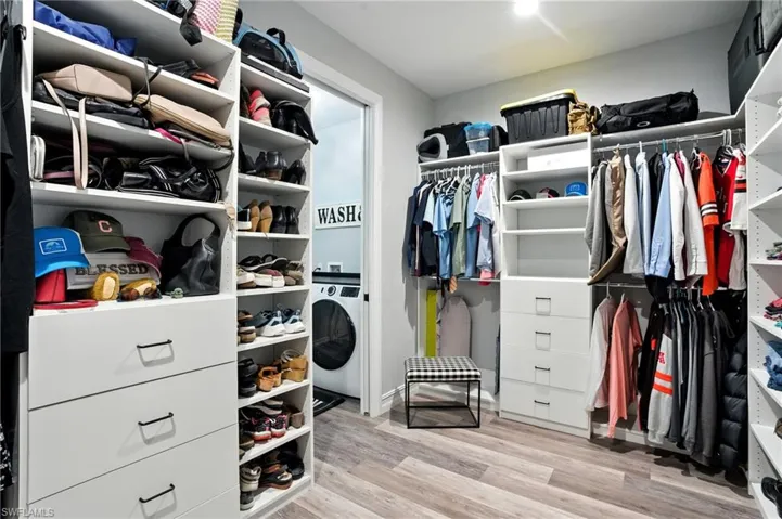 Spacious closet with light wood-type flooring and washer / clothes dryer