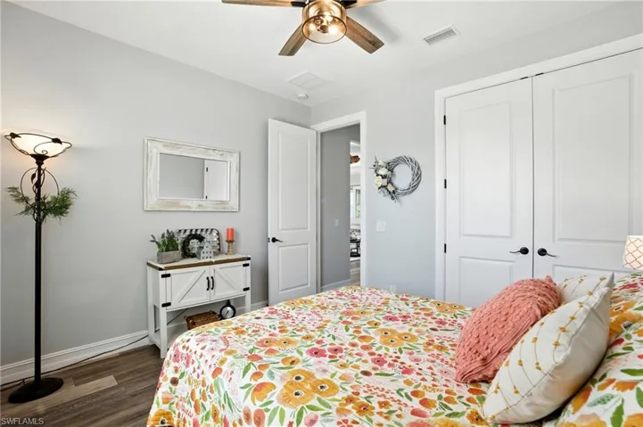 Bedroom featuring dark wood finished floors, a closet, and a ceiling fan