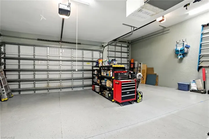 Garage featuring a garage door opener and a textured wall
