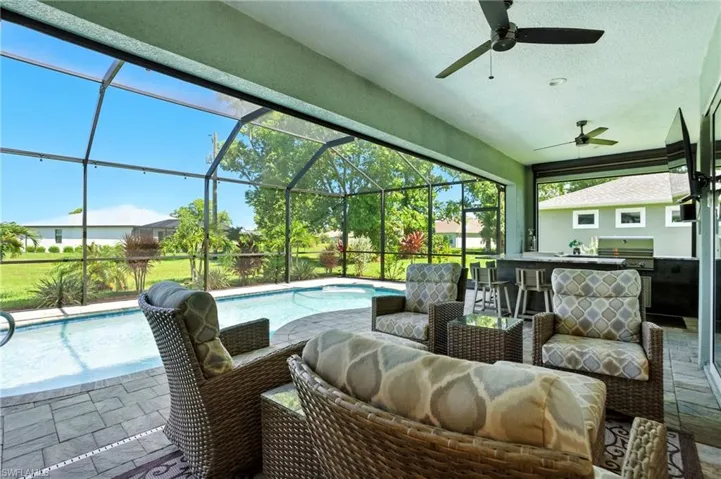 Swimming pool with a grill, a sunroom, a patio, and a lanai