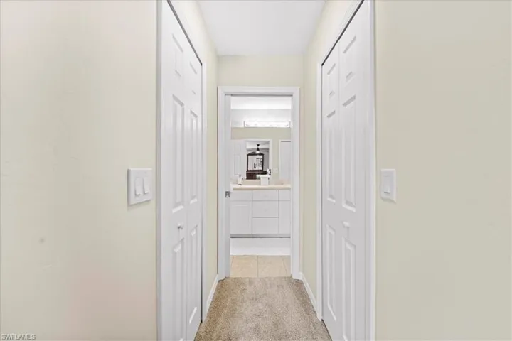 Hall featuring light colored carpet and baseboards