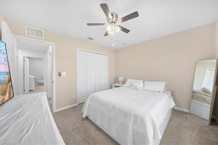 Bedroom featuring ceiling fan, a closet, and carpet