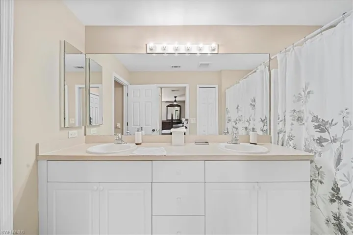 Bathroom featuring double vanity and curtained shower