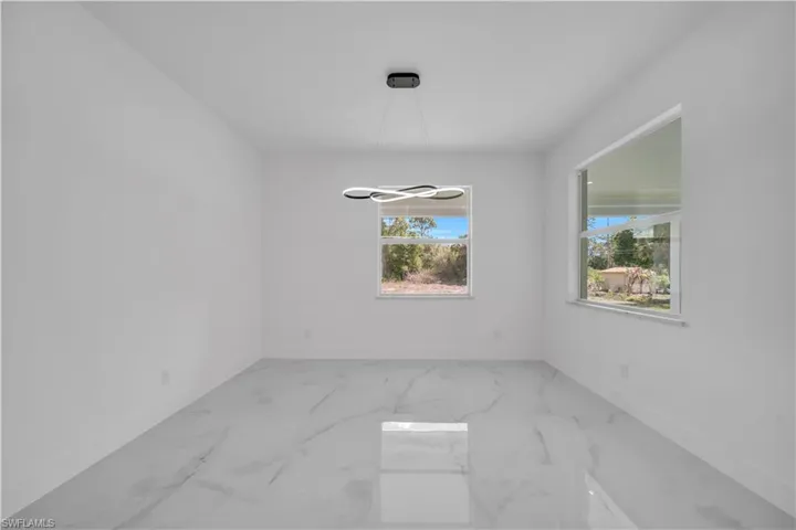 Unfurnished dining area featuring baseboards and light marble finish flooring