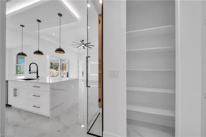 Bathroom featuring vanity, recessed lighting, and light marble finish flooring