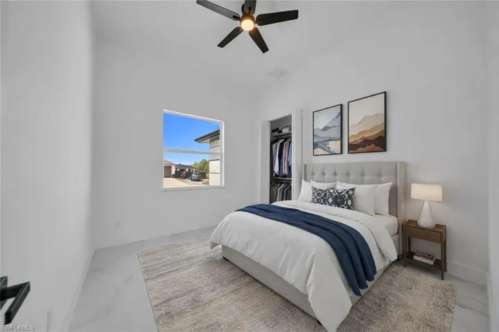 Bedroom featuring a spacious closet and ceiling fan