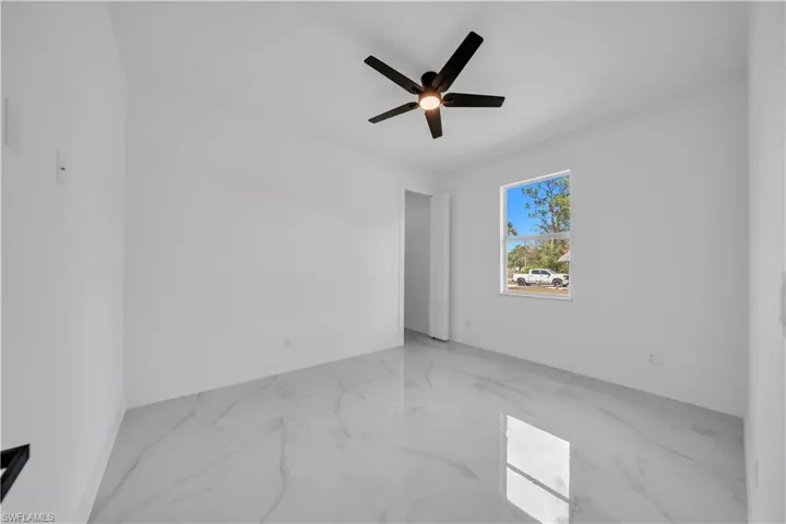 Spare room with ceiling fan and light marble finish flooring