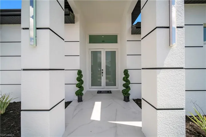 Doorway to property with french doors and stucco siding