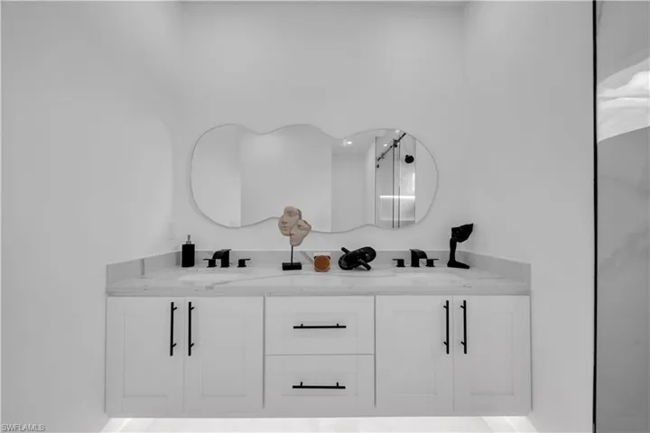 Full bath featuring double vanity and an enclosed shower