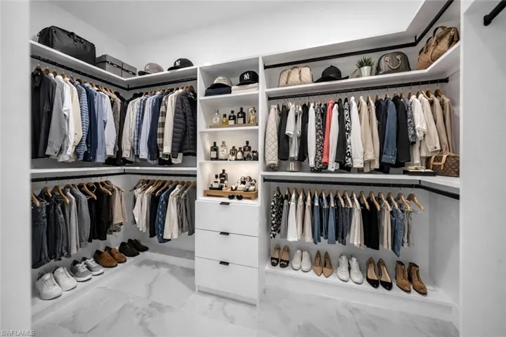Walk in closet featuring light marble finish flooring