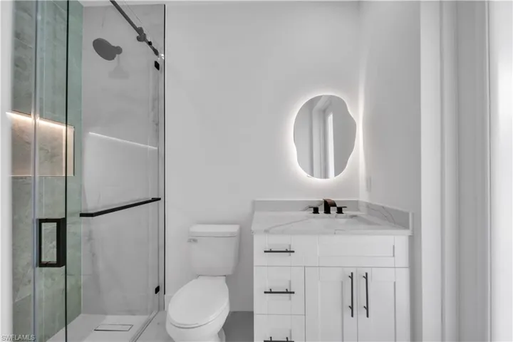 Bathroom with vanity and a marble finish shower
