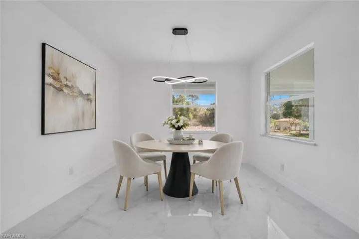 Dining room with baseboards and light marble finish floors