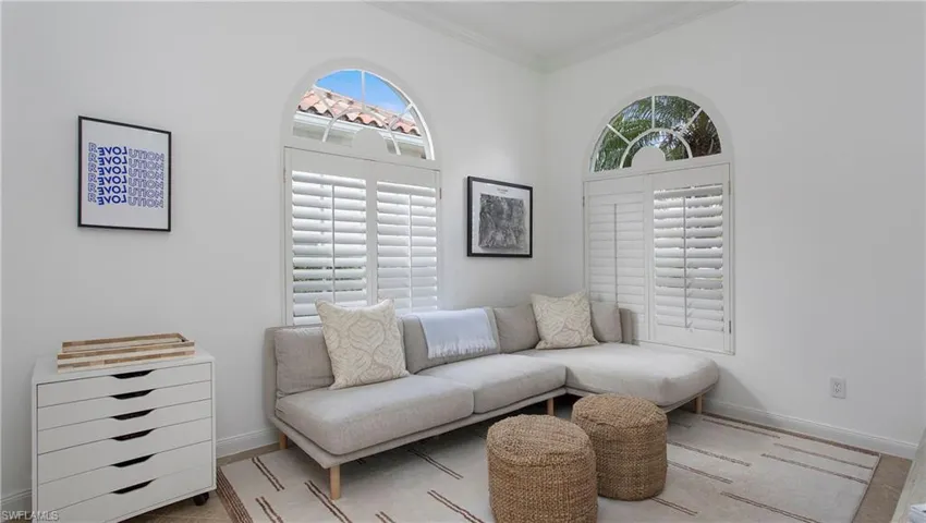 Living room with crown molding and a wealth of natural light