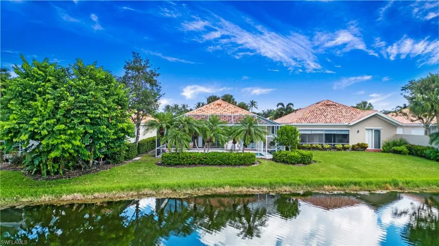 Rear view of house with a lawn and a water view