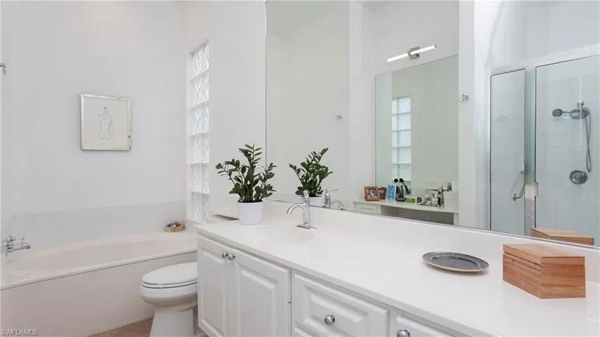 Full bathroom with vanity, toilet, plus walk in shower, and plenty of natural light