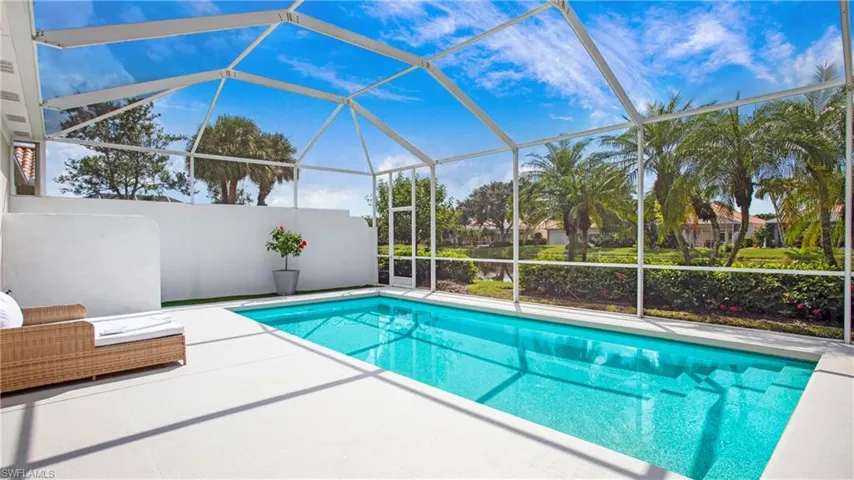 View of pool with glass enclosure and a patio area