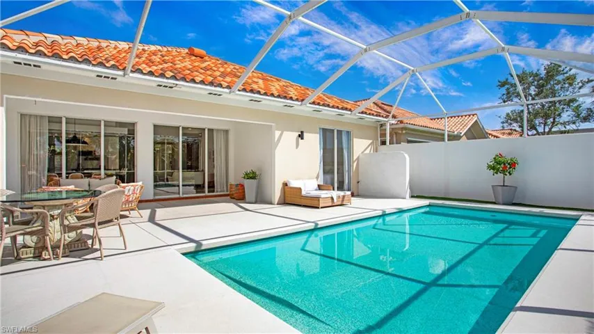 View of swimming pool with an outdoor living space, glass enclosure, and a patio
