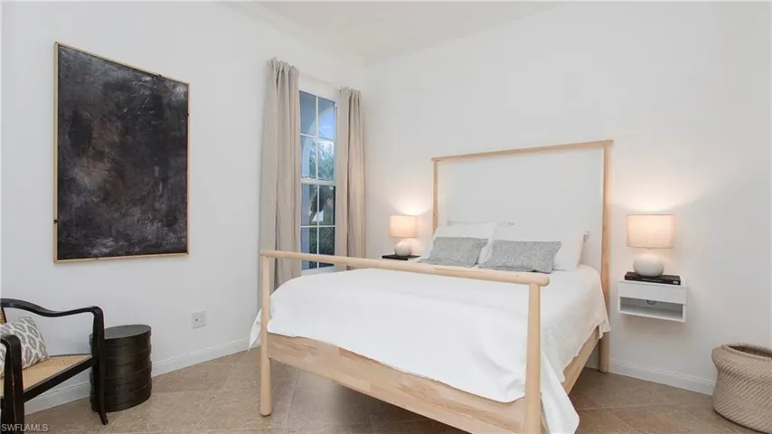 Bedroom with light tile patterned floors and ornamental molding