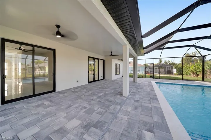 Outdoor pool featuring a patio, a lanai, and a ceiling fan