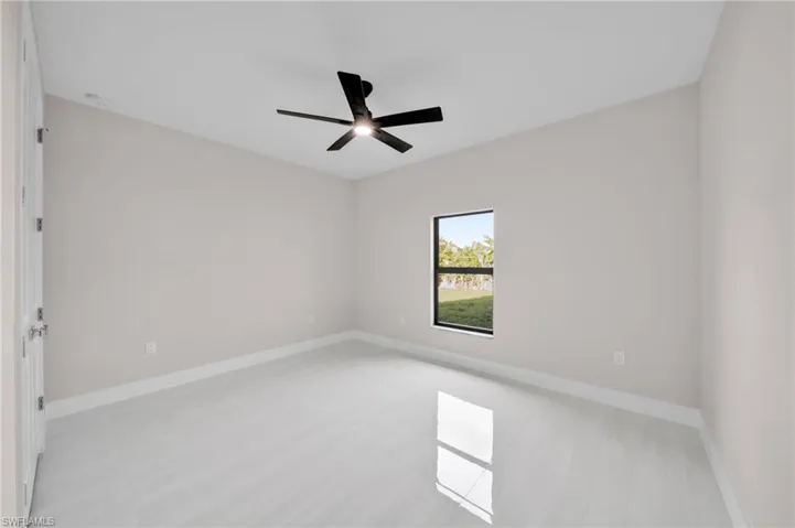 Empty room with a ceiling fan and baseboards