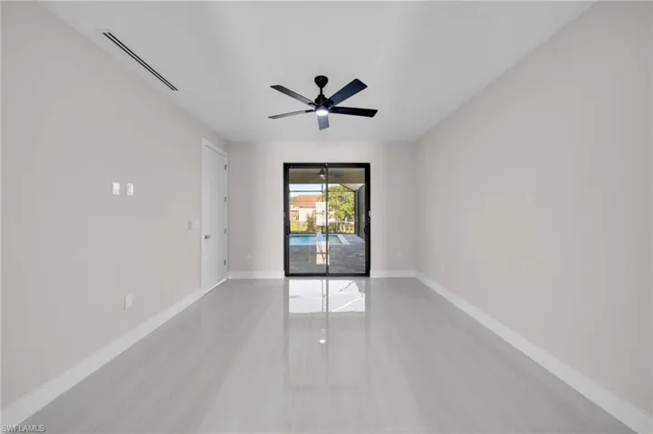 Unfurnished room featuring baseboards, visible vents, light tile patterned floors, and a ceiling fan