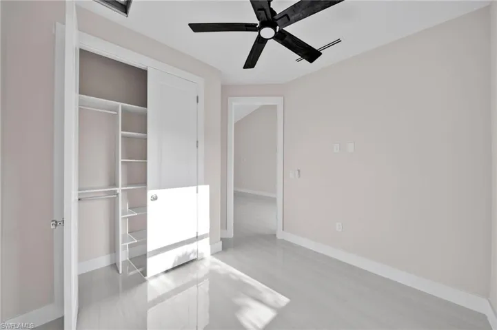 Unfurnished bedroom with a closet, a ceiling fan, and baseboards