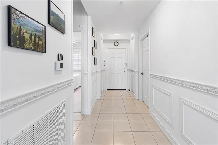 CORRIDOR FEATURING DECORATIVE CHAIR RAILING PLUS WAINSCOTING ADD TO THE LUXURY IN THIS CONDO THAT SEPARATES IT FROM THE REST!