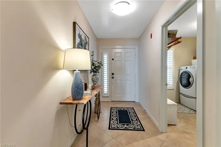 Foyer entrance featuring light tile patterned floors and washer / clothes dryer