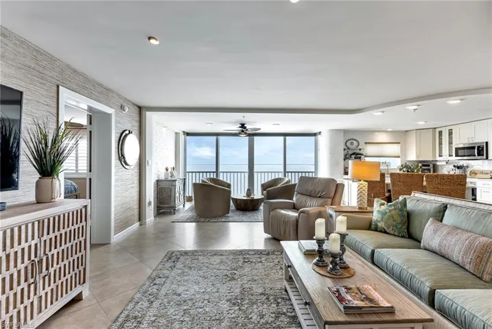 Living room with light tile patterned floors, ceiling fan, and recessed lighting