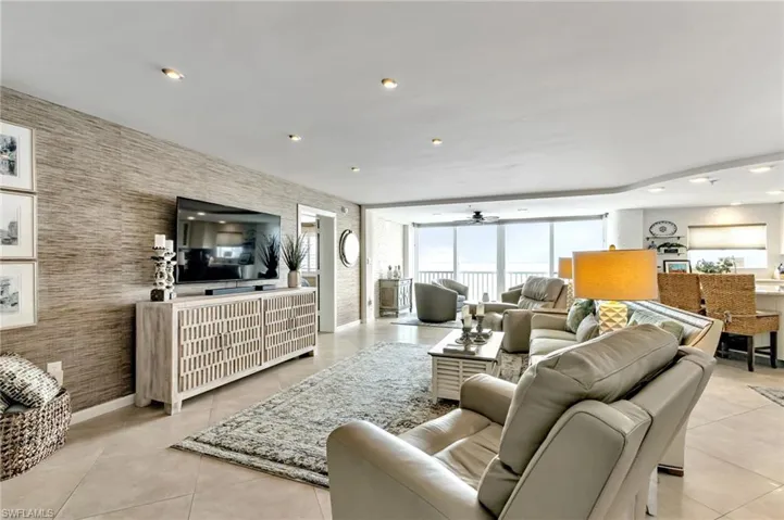 Living room featuring a ceiling fan, recessed lighting, an accent wall, wallpapered walls, and light tile patterned floors