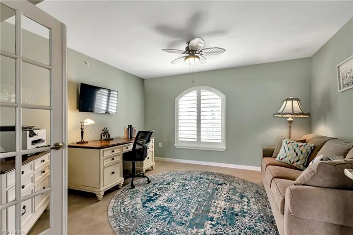 Office with a ceiling fan and light tile patterned flooring