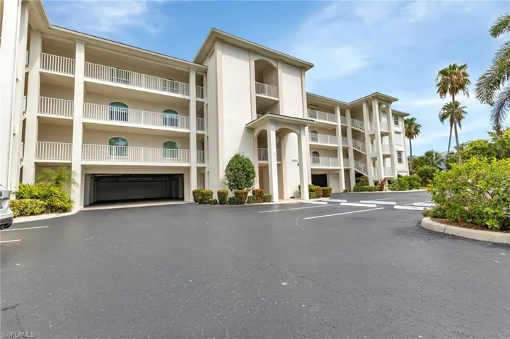 View of apartment building / complex featuring uncovered parking