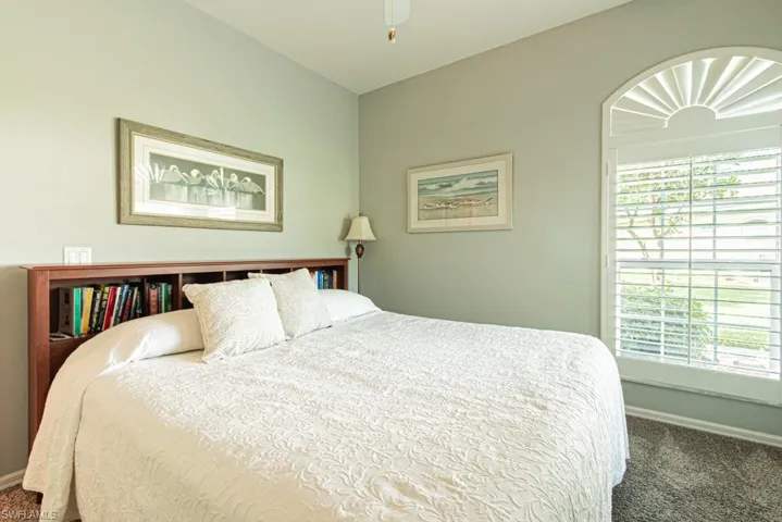 Carpeted bedroom featuring baseboards and ceiling fan