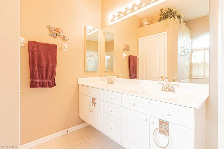 Full bath featuring double vanity and tile patterned flooring