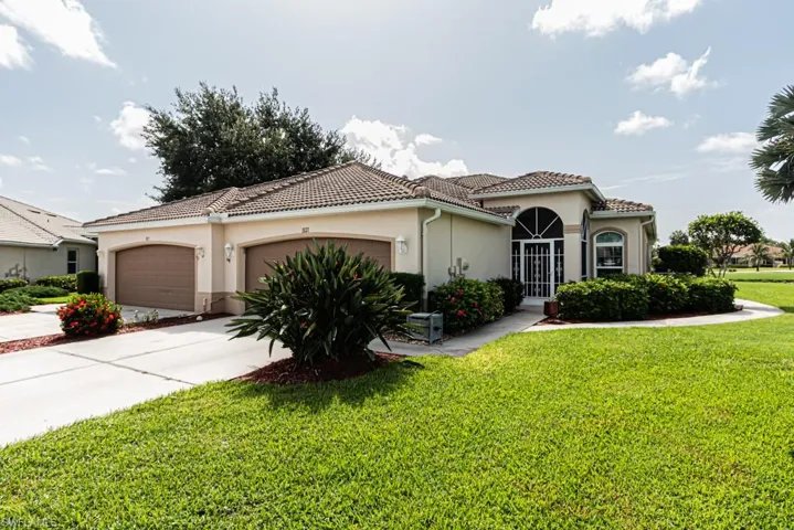 Mediterranean / spanish house featuring stucco siding, an attached garage, a front yard, and a tiled roof