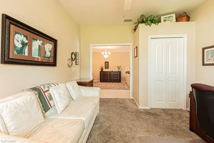 Carpeted living area featuring tile patterned floors and a ceiling fan