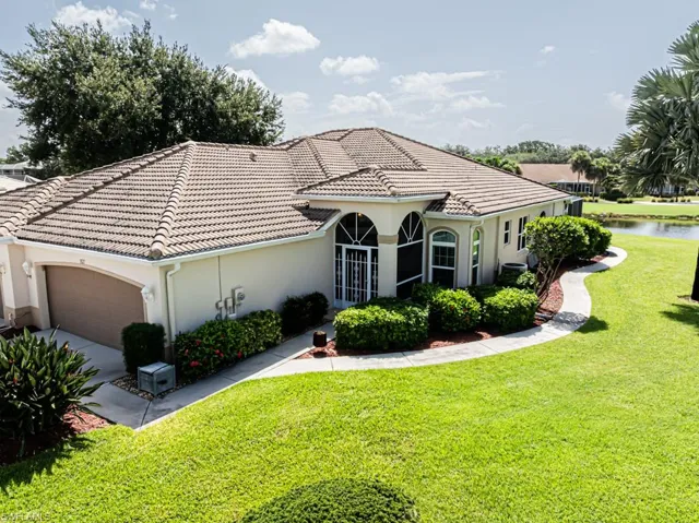 Mediterranean / spanish-style home with a garage, stucco siding, a front yard, and driveway
