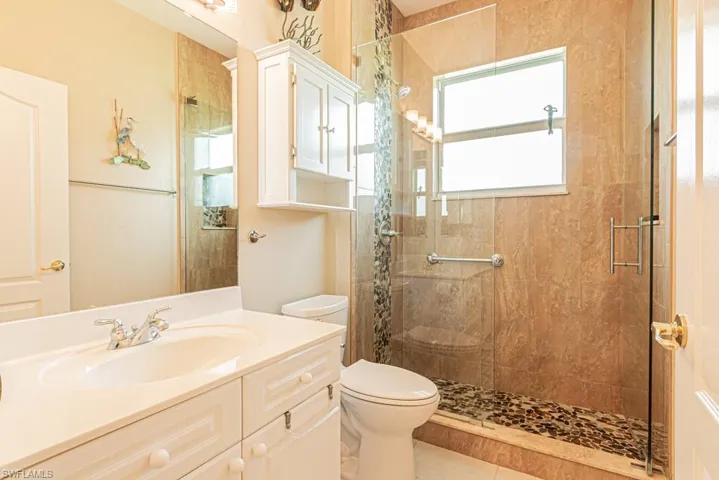 Full bathroom featuring a shower stall, vanity, and tile patterned flooring