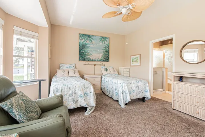 Bedroom featuring carpet floors, ensuite bathroom, and ceiling fan