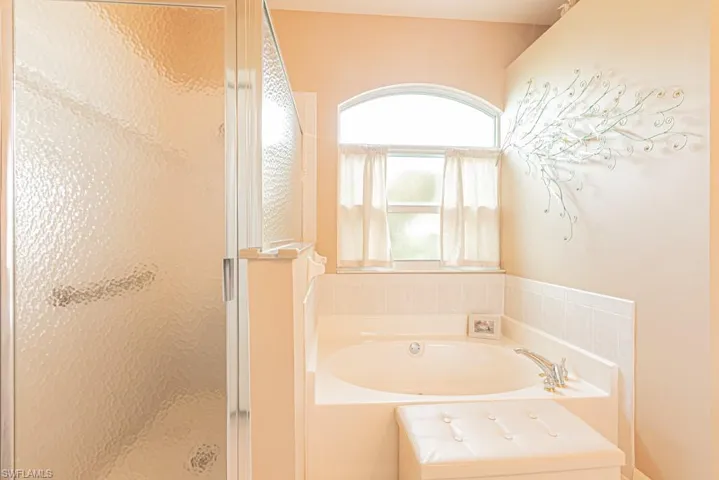 Bathroom featuring a shower stall and a bath