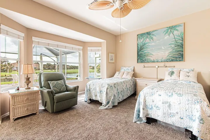 Bedroom featuring carpet flooring, a ceiling fan, and a water view