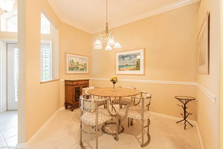 Dining room with crown molding, a chandelier, and tile patterned floors