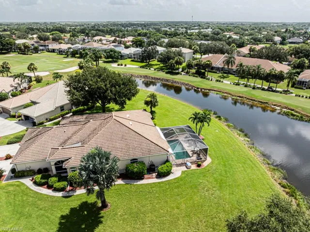 Aerial view of residential area featuring a nearby body of water and a local golf course