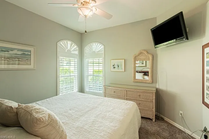 Carpeted bedroom featuring baseboards and a ceiling fan