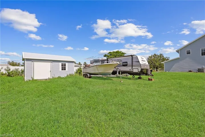 View of grassy yard with a storage unit