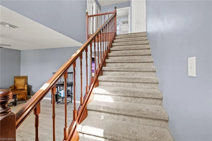 Stairs with wood finished floors and baseboards