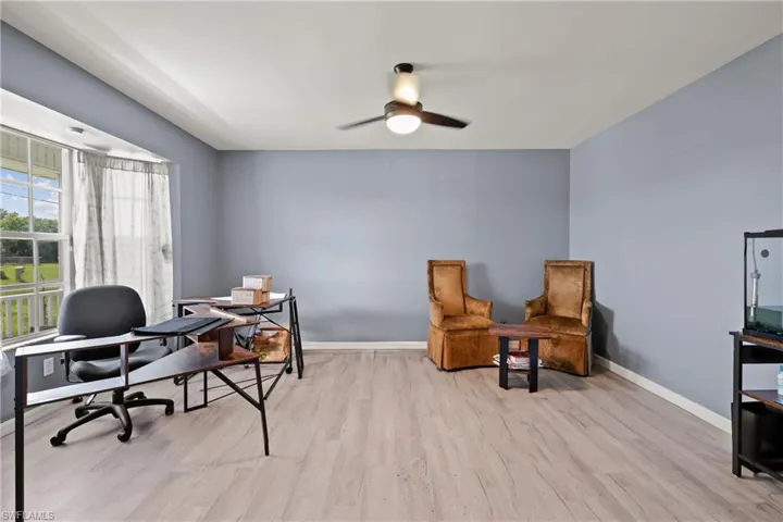Office area with light wood finished floors and ceiling fan