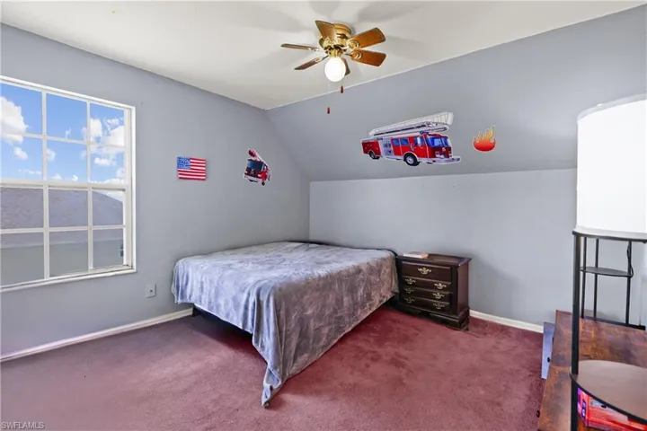 Bedroom featuring carpet, vaulted ceiling, and ceiling fan